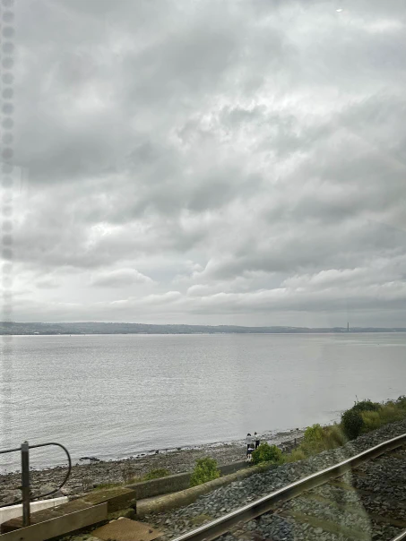 A view of cloudy skies with dramatic light seen from a train window.