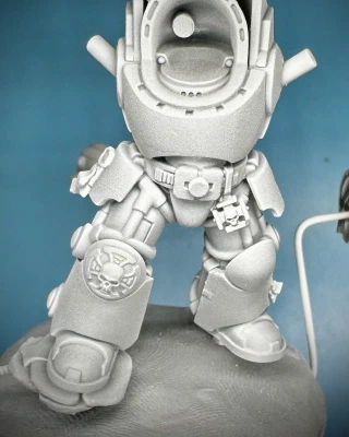 A white-on-grey primed Games Workshop Terminator mini.