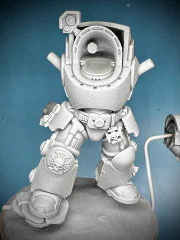A white-on-grey primed Games Workshop Terminator mini.