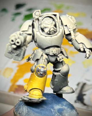 A 40K terminator miniature WIP still showing mainly primer. But his boot is yellow.
