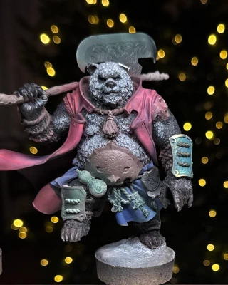 Three miniatures in various early stages of being painted  (and repaired). A little half-yellow guy, a little partly-green guy, and one great big guy missing a left ear. Festive background lights though, so all is well.