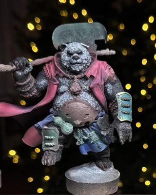 Three miniatures in various early stages of being painted  (and repaired). A little half-yellow guy, a little partly-green guy, and one great big guy missing a left ear. Festive background lights though, so all is well.