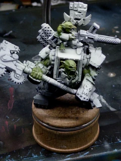 A friendly, smiling 40K Ork and chum. A green base layer has been applied as a starting skin tone and the surrounding areas ‘cleaned up’ with white overspray. There are small spots of white remaining on the green where the masking layer didn’t fully detach.
