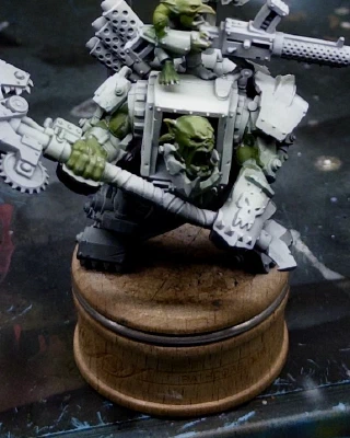 A friendly, smiling 40K Ork and chum. A green base layer has been applied as a starting skin tone and the surrounding areas ‘cleaned up’ with white overspray. There are small spots of white remaining on the green where the masking layer didn’t fully detach.