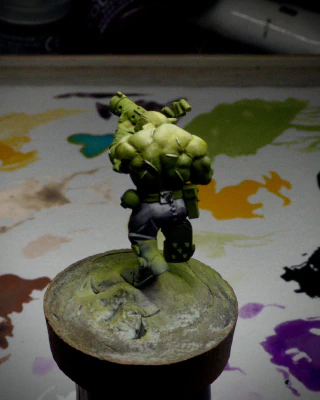 Purple trousers and a darkly reflective belt gubbin (can’t be a buckle, it’s on the wrong side. And appears to have rivets) have been added, unnecessarily accentuating the backside.