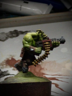 A side view of the Ork! Secret reveal that this was not a 2D standee all along. The photo quality isn’t great, but I’m trying to give the impression of two different metallics, ‘brass’ and ‘gunmetal’. Both started as sketchy monochrome, then colour washes. I think the brass might work with another contrast pass, but the ‘gunmetal’ barrel is an outright powdery-grey failure. Must try harder, A-.

