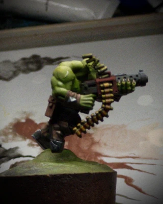 A side view of the Ork! Secret reveal that this was not a 2D standee all along. The photo quality isn’t great, but I’m trying to give the impression of two different metallics, ‘brass’ and ‘gunmetal’. Both started as sketchy monochrome, then colour washes. I think the brass might work with another contrast pass, but the ‘gunmetal’ barrel is an outright powdery-grey failure. Must try harder, A-.