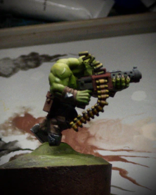 A side view of the Ork! Secret reveal that this was not a 2D standee all along. The photo quality isn’t great, but I’m trying to give the impression of two different metallics, ‘brass’ and ‘gunmetal’. Both started as sketchy monochrome, then colour washes. I think the brass might work with another contrast pass, but the ‘gunmetal’ barrel is an outright powdery-grey failure. Must try harder, A-.