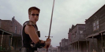 Weirdly, not a parody image. Fox Mulder wielding a sword in the old west wearing laser tag armour, elbow pads, and shades.