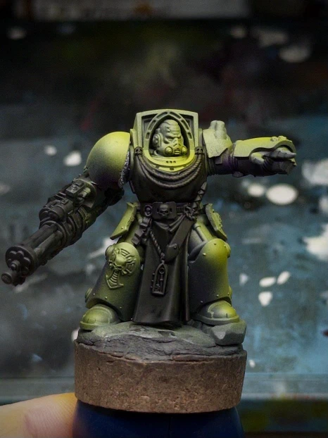 The mini’s bib, gun and chic accessories are blacked out while the armour was given an initial dark green base tone and progressively airbrushed with yellow highlights. Violet ink shades the deepest shadows.